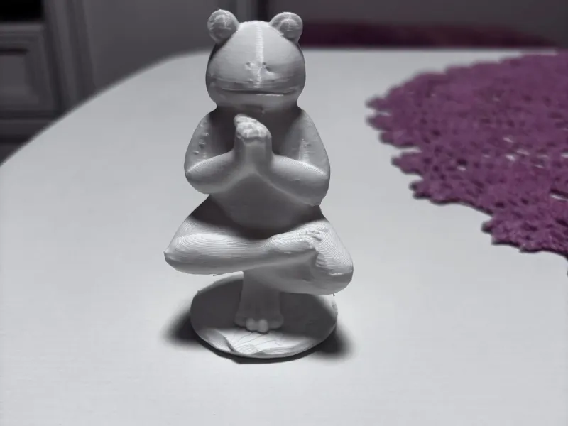 Tuindecoratie van een kikker die yoga doet