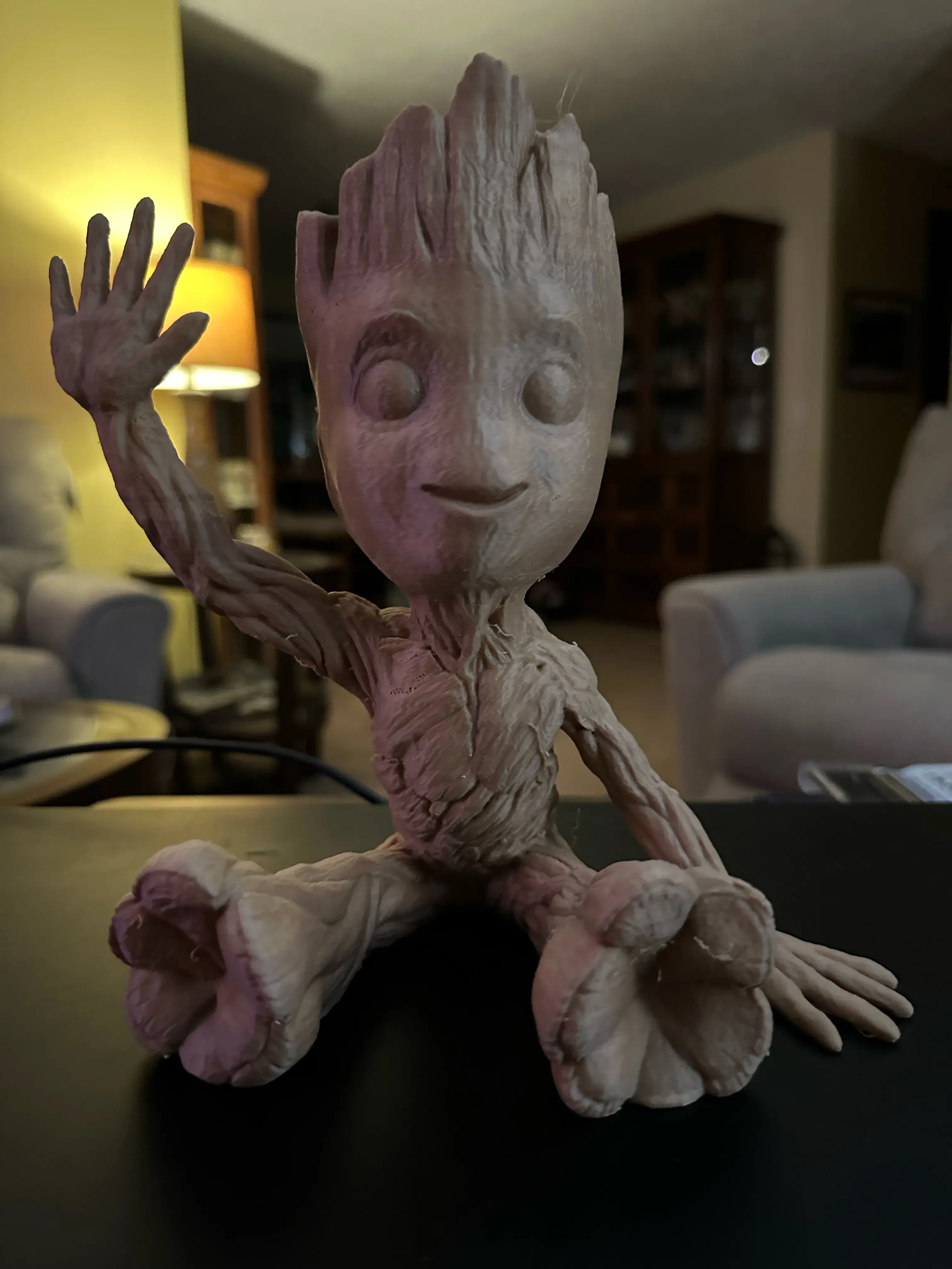 Baby Groot sitzend winkend