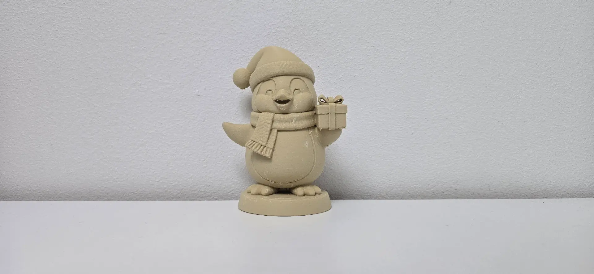 Smiling Penguin with Santa Hat and Gift Christmas Figurine