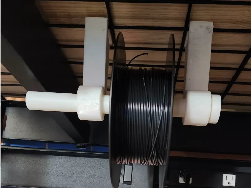 Hanging spool holder for shelving rack
