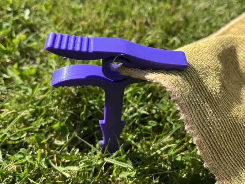 Peg to hold beach blanket against wind
