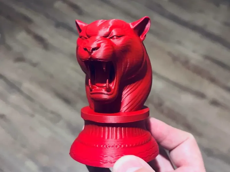 Escultura em miniatura da cabeça de animal sobre leopardo