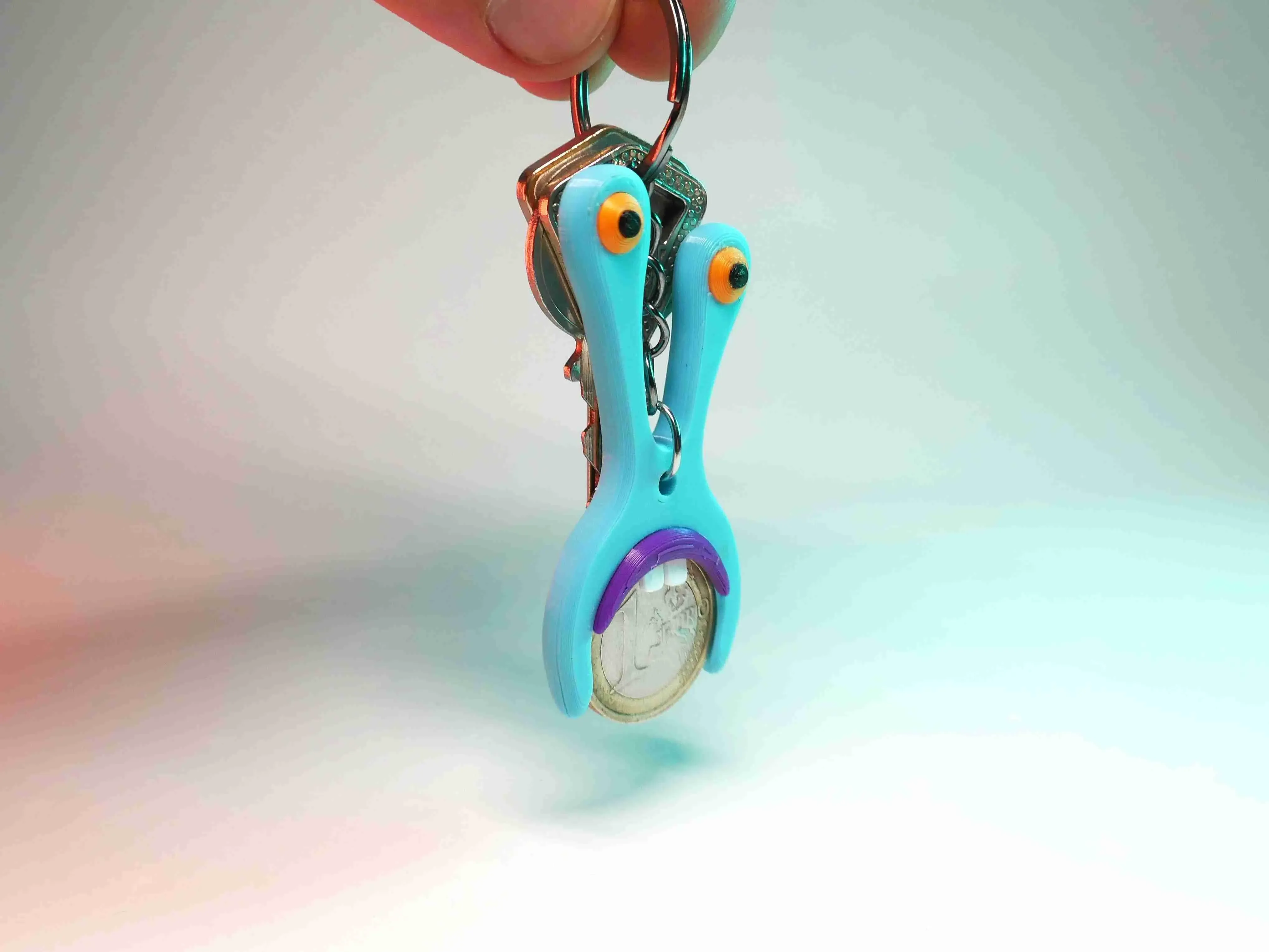 AN AMOEBA-SHAPED KEYCHAIN, SUITABLE FOR 1 AND 2 EURO COINS