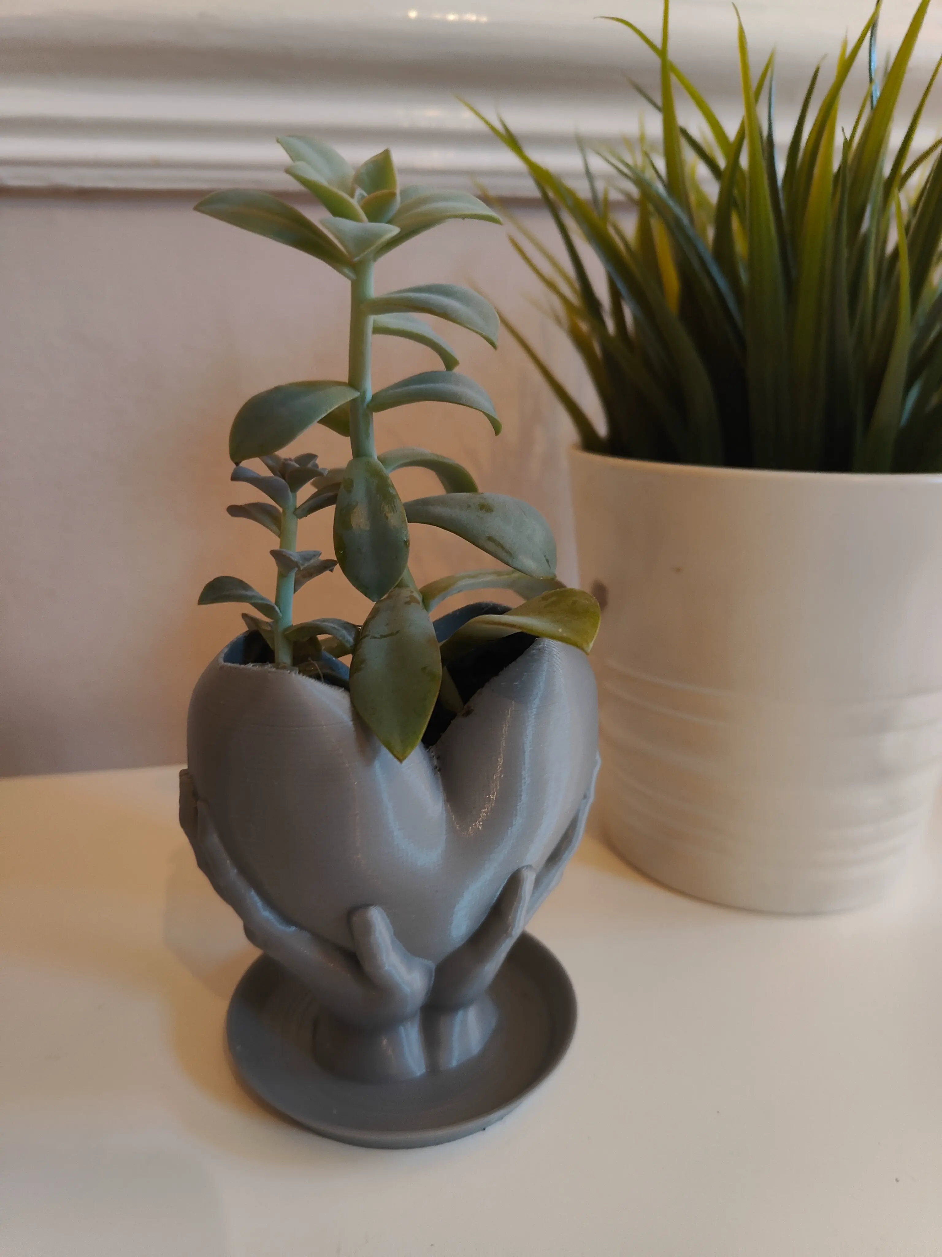 Hands holding heart planter with drainage