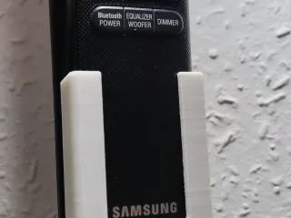 Wall mounted soundbar remote control holder.