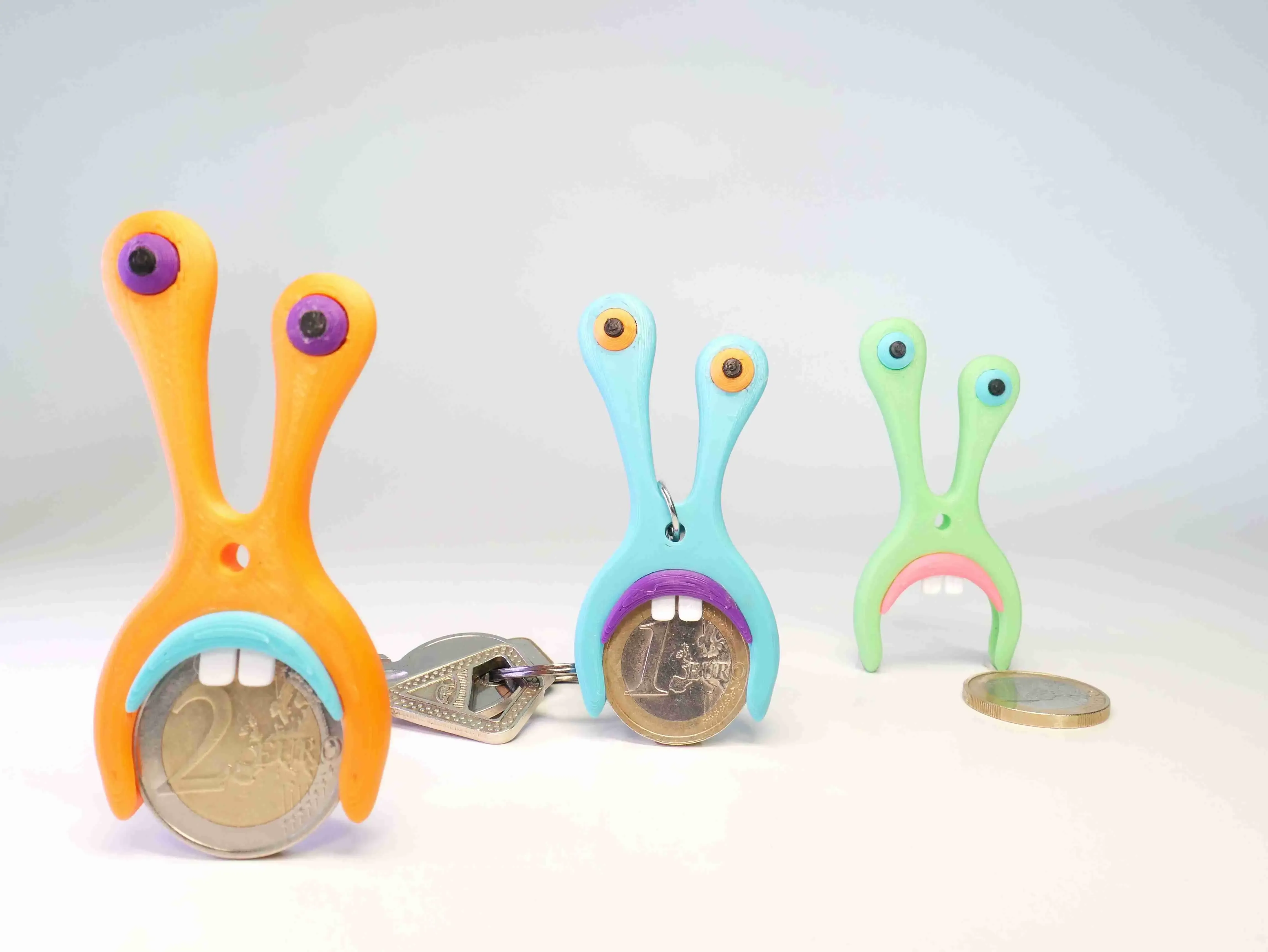 AN AMOEBA-SHAPED KEYCHAIN, SUITABLE FOR 1 AND 2 EURO COINS