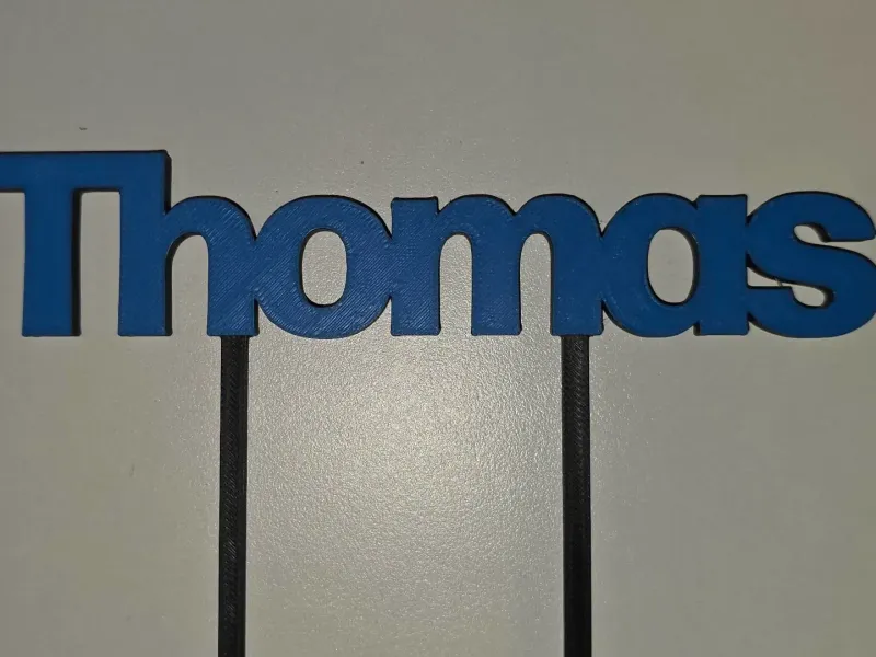 Thomas Cake Topper. Blue text and black body.