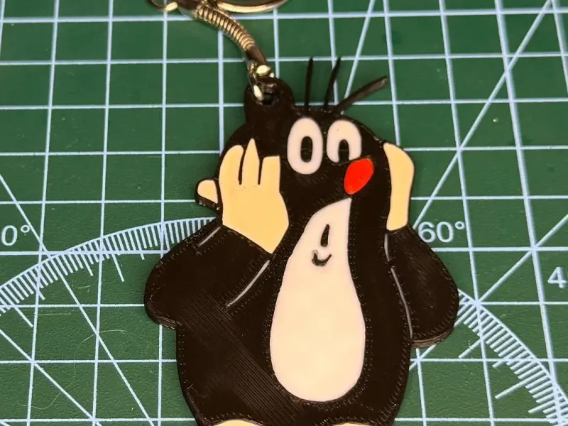 a keychain with a Mole (Krecik) cartoon motif