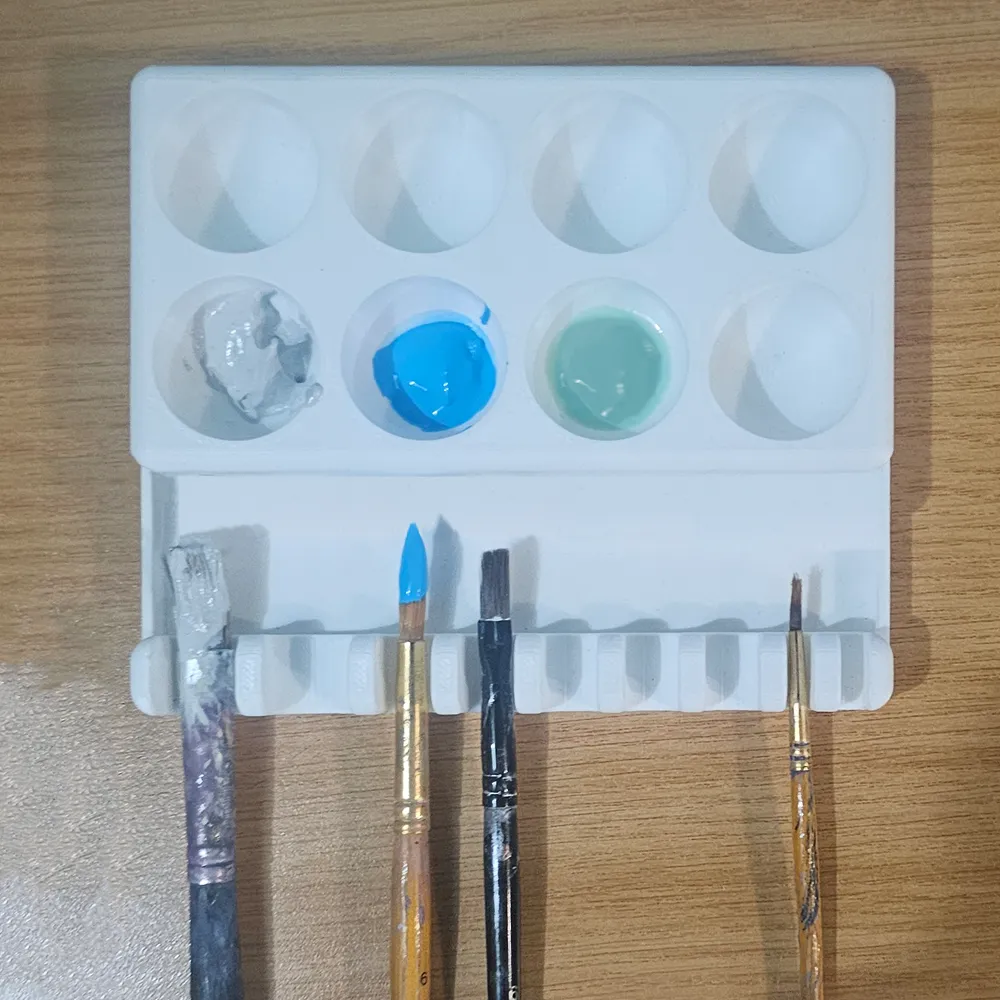 Paleta de pintura con soportes para pinceles