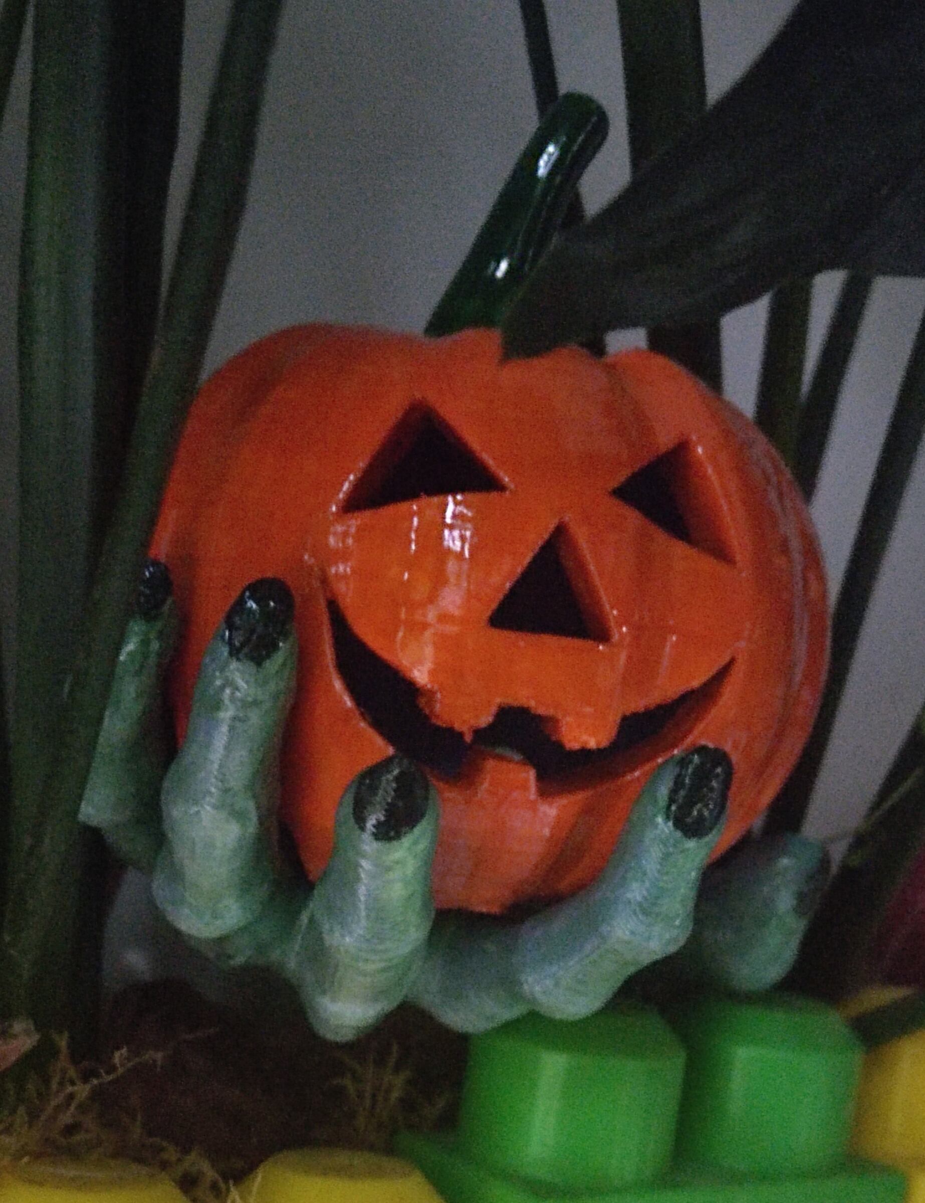A pumpkin in a Zombie hand