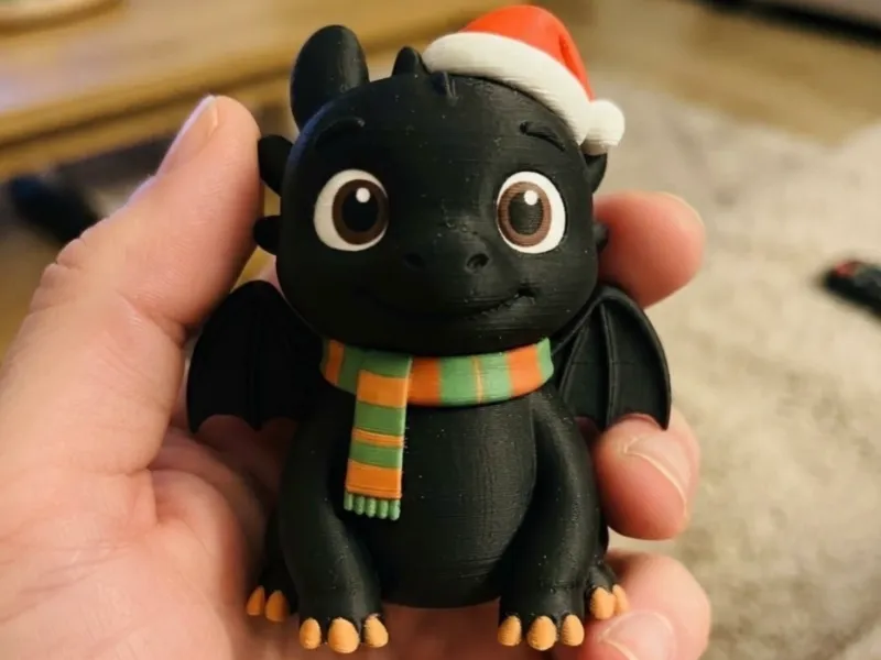 Adorable dragón de invierno con gorro de Papá Noel y bufanda