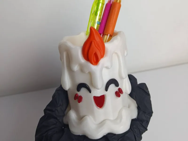 A multi-piece, multi-colored candle-shaped pen holder.