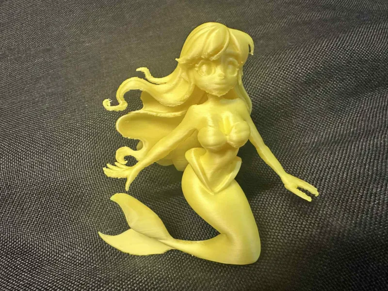 Figurina di sirena anime con capelli fluenti e coda curva