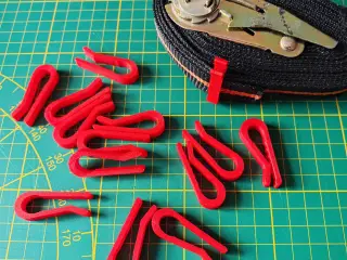 Securing clips for ratchet straps