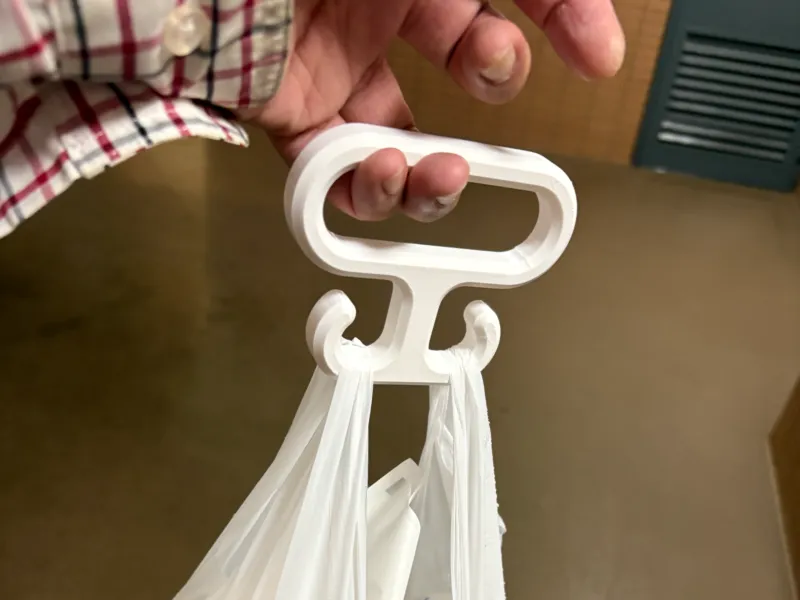 Un gancho que hace que llevar bolsas de plástico sea más cómodo.