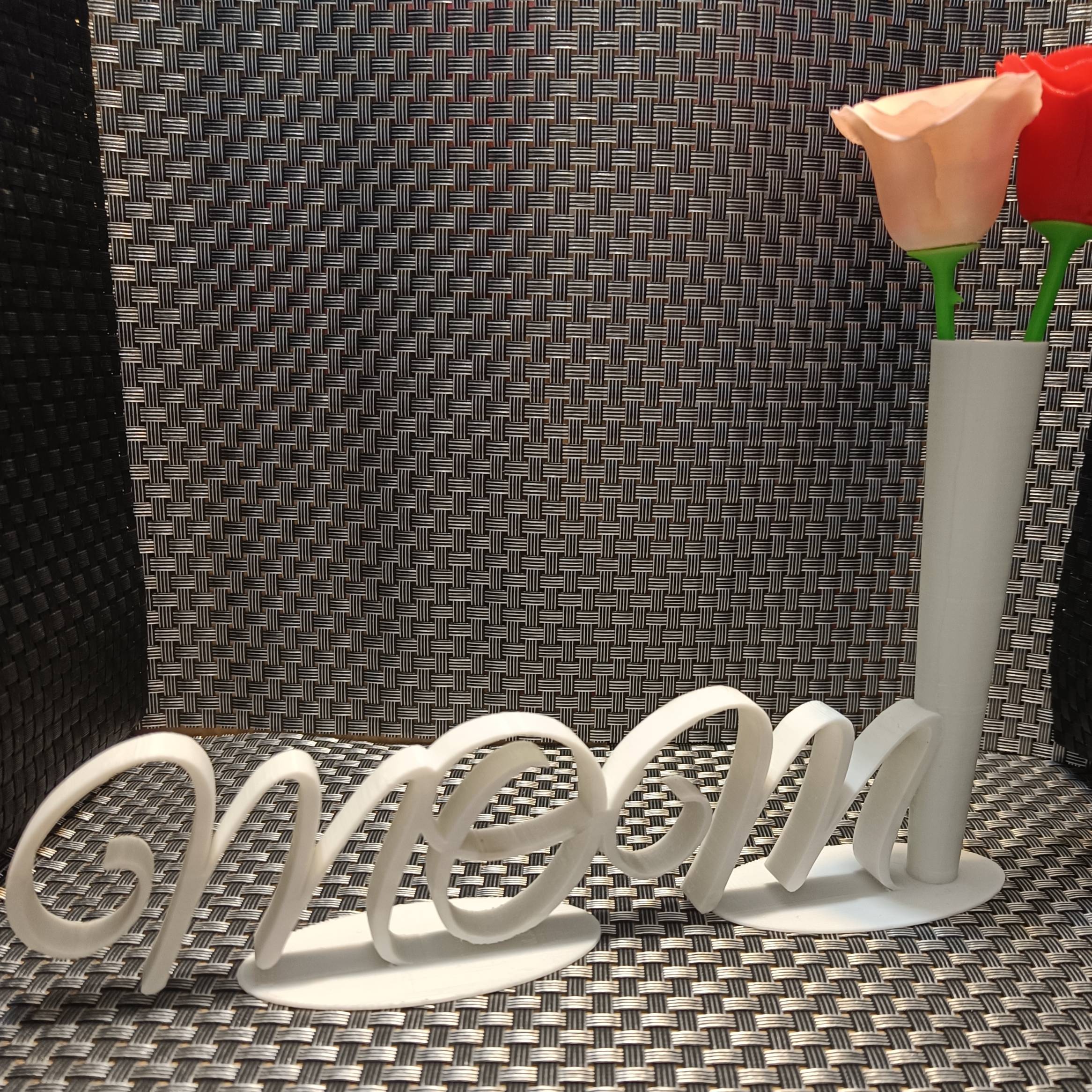The inscription "mom" and a flower vase -napis mom oraz waza