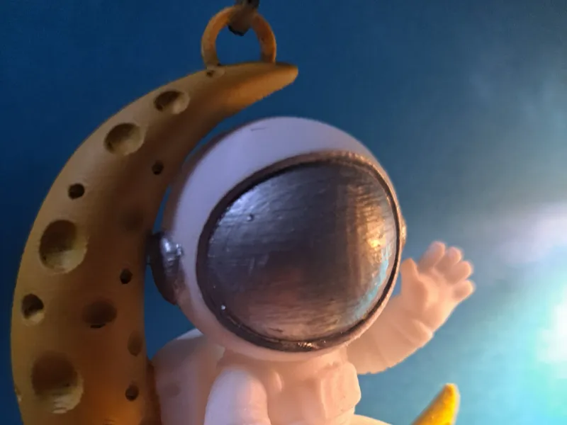 Hanging waving astronaut on Crescent Moon