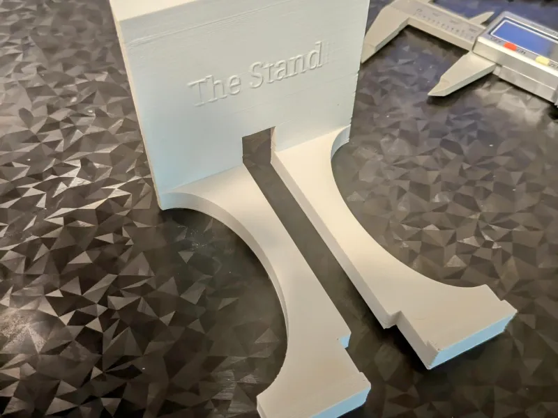 "Le Socle" Un support de téléphone simple avec enrouleur de câble au dos.