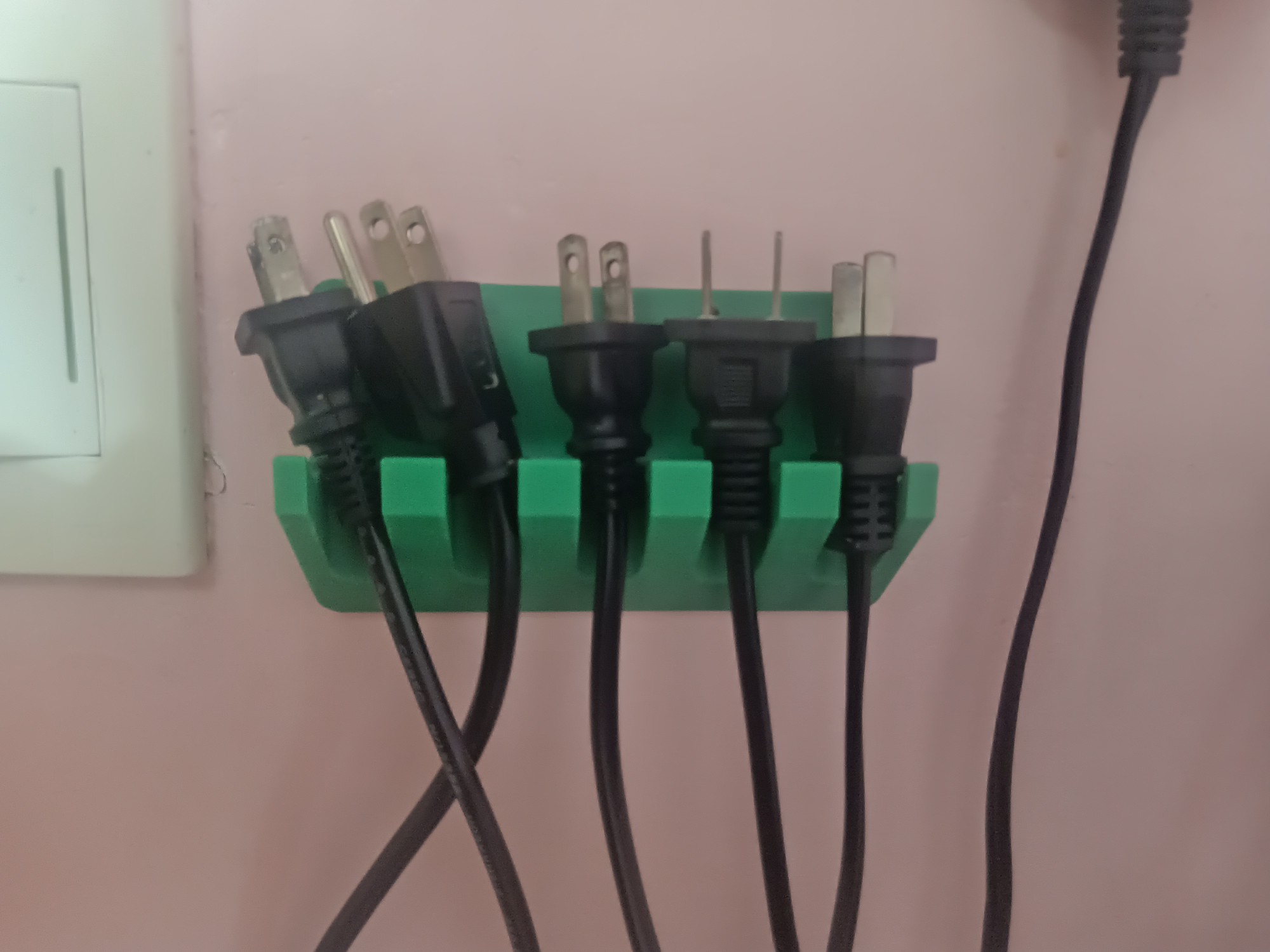 Wall mounted phone holder and power plug hanger